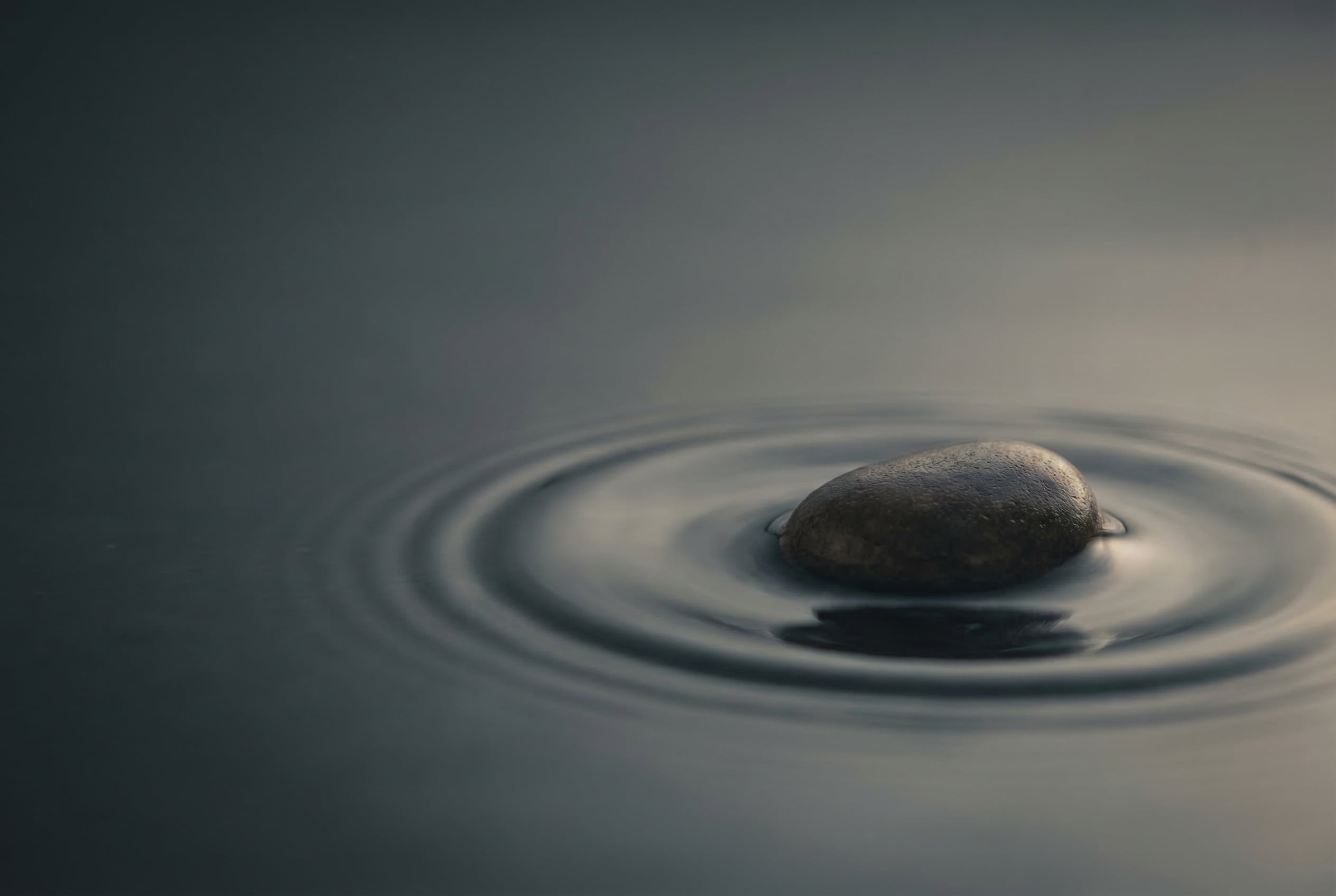 Frau in entspannter Pose auf einer Wiese, symbolisiert Stressbewältigung
